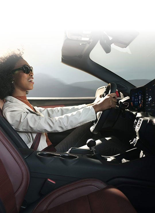Person sitting in the driver’s seat of a 2024 Ford Mustang® convertible | Davis Ford Sales, Inc. in Fulton MS