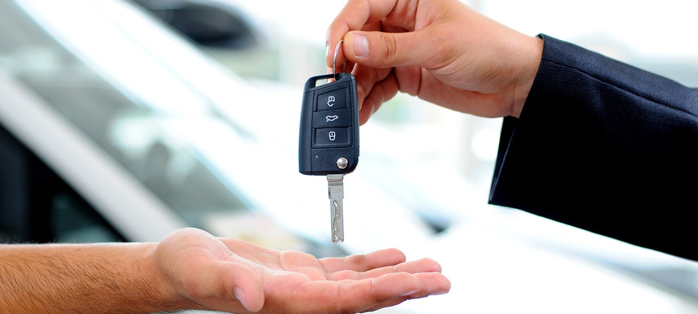 car salesman passing a key
